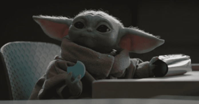 Baby Yoda enjoys a snack while in a classroom.