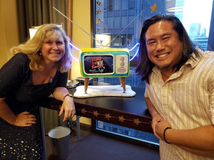 Author Randee Dawn and cake artist Mark Lie with a custom cake featuring Dawn's book Tune in Tomorrow