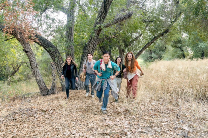 Ben, Addison's hologram, and three teens run through a dry forest